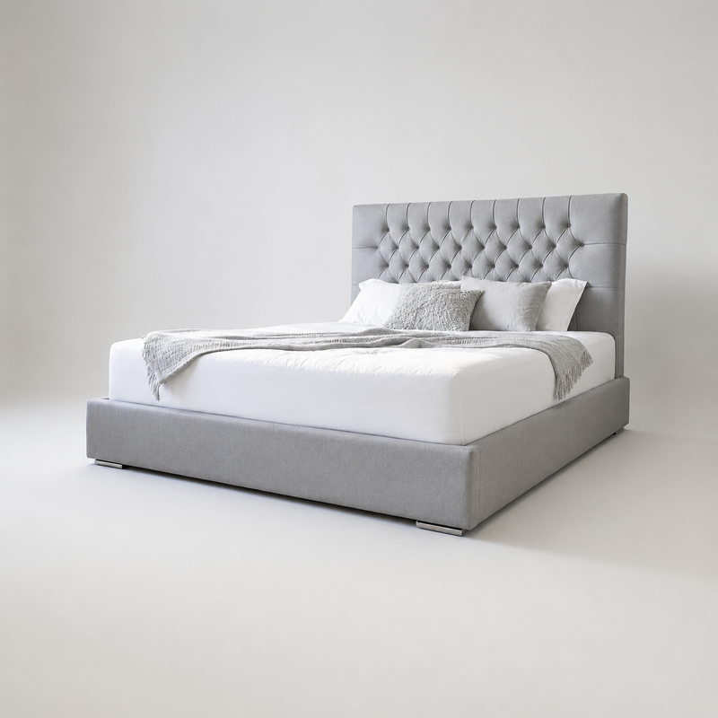 Gray upholstered sleigh bed with tufted design headboard.